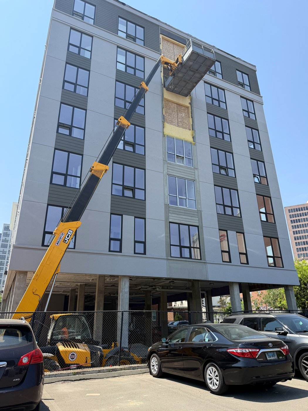 Lift equipment unloading shower glass door materials at building site